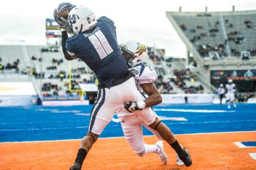 Chris Detrick  |  The Salt Lake Tribune
Utah State Aggies wide receiver Brandon Swindall (11) can't hold on to a potential touchdown pass while being covered by Akron Zips cornerback Kris Givens (21) during the Famous Idaho Potato Bowl at Albertsons Stadium in Boise, Idaho Tuesday December 22, 2015.  Akron Zips lead Utah State Aggies 13-7 at halftime.