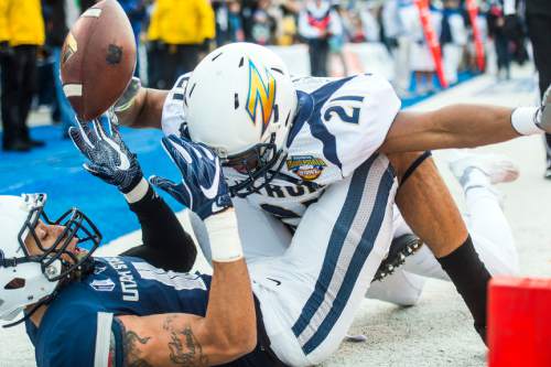 Chris Detrick  |  The Salt Lake Tribune
Utah State Aggies wide receiver Brandon Swindall (11) falls out of the end zone and looses control of the ball while being covered by Akron Zips cornerback Kris Givens (21) during the Famous Idaho Potato Bowl at Albertsons Stadium in Boise, Idaho Tuesday December 22, 2015.  Akron Zips lead Utah State Aggies 13-7 at halftime.