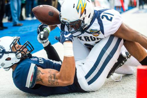 Chris Detrick  |  The Salt Lake Tribune
Utah State Aggies wide receiver Brandon Swindall (11) falls out of the end zone and looses control of the ball while being covered by Akron Zips cornerback Kris Givens (21) during the Famous Idaho Potato Bowl at Albertsons Stadium in Boise, Idaho Tuesday December 22, 2015.  Akron Zips lead Utah State Aggies 13-7 at halftime.