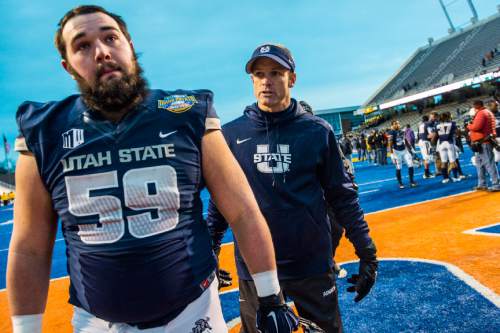Chris Detrick  |  The Salt Lake Tribune
Utah State Aggies center Austin Stephens (59) and Utah State Aggies head coach Matt Wells walk off of the field after the Famous Idaho Potato Bowl at Albertsons Stadium in Boise, Idaho Tuesday December 22, 2015.  Akron Zips defeated Utah State Aggies 23-21.