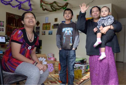 Leah Hogsten  |  The Salt Lake Tribune
Burmese refugees Farida Abdul, left, brother Hassan Abdul, mother Hasena Osman holding daughter Natasha, receive gifts on Christmas day, December 25, 2015 to their home. Shalom, Salaam ñ Tikkun Olam Christmas Day Project, is a project that reaches hundreds in need, including 100 refugee families and 350 seniors, as well as residents of area shelters. The charity includes more than 300 volunteers from diverse religious, cultural, and educational backgrounds who prepare and deliver packages made up of food, household goods, gifts, and gift cards, all of which are donated by participating retailers or purchased with donated funds.