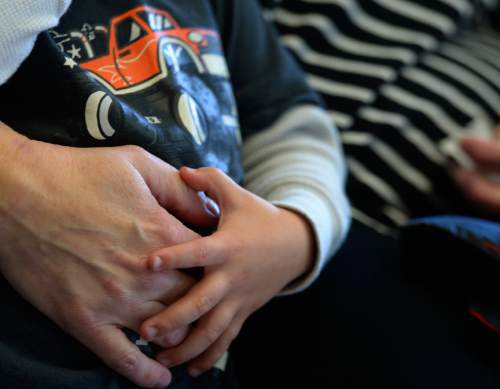 Leah Hogsten  |  The Salt Lake Tribune
Nicki Bidlack's son grips his mother's hand, December 24, 2015. Bidlack and her longtime partner, Sara Clow, who died before they could formally marry, secured what is believed to be the first recognition of a common law LGBT marriage from the 2nd District Court. The ruling allowed Bidlack to secure a new birth certificate for their son, which names both women as his parents.