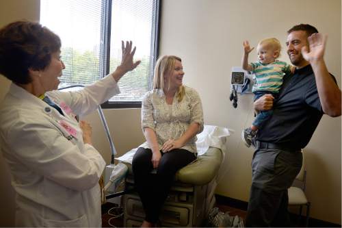 Scott Sommerdorf   |  The Salt Lake Tribune
Two year old Ryan Wangsgard and his father David, right, wave to Dr. Vicki L. Macy, MD, OBGYN, as Ryan's mother Sarah watches at center, during the last pregnancy check-in they'll have with Macy at Salt Lake Regional Medical Center, Wednesday, September 30, 2015.