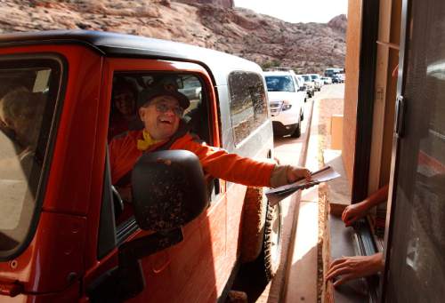 Leah Hogsten | The Salt Lake Tribune

Wade Monutz of Colorado Springs enters Arches National Park on October 12, 2013. There was a minimum 15-minute wait time for vehicles waiting for entrance to Arches National Park. Thanks to a $1.7 million payment from Utah taxpayers, the national parks of southern Utah were exempted from the federal government shutdown just in time for a traditionally busy fall weekend.