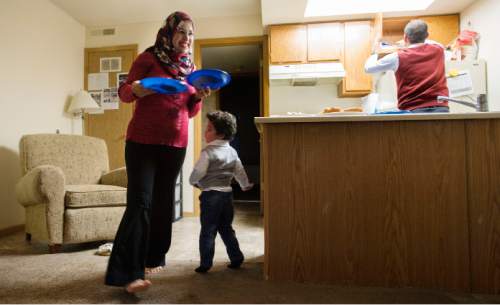 Steve Griffin  |  The Salt Lake Tribune

Mohammed Alhareb, right, and his wife, Sarah Alsahyem, and 2-year-old son, Ridha Alhareb, prepare snacks for guests in their home in Millcreek, Friday, Dec. 18, 2015.  The family has been in Utah  for nine months since leaving Iraq.
