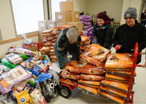 Francisco Kjolseth | The Salt Lake Tribune
Kevin Lawson, left, Hannah McNabb and Kiera Packer unload bags of donated dog food after a three-month holiday donation drive to help Salt Lake County Animal Services.