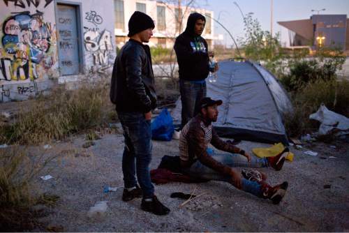 In this photo taken on Wednesday, Dec. 23, 2015, migrants from Morocco stand next to their tent as they wait to enter a camp in Athens. More than a million people fleeing war or poverty at home reached European countries in 2015 in the largest refugee influx the continent has seen since the end of World War II _ a crisis that has tested European unity and pressured the vision of a borderless continent. Greece, the European Union's most financially troubled member, has borne the brunt of the exodus with more than 850,000 people reaching the country's shores, nearly all arriving on Greek islands from the nearby Turkish coast. (AP Photo/Petros Giannakouris)