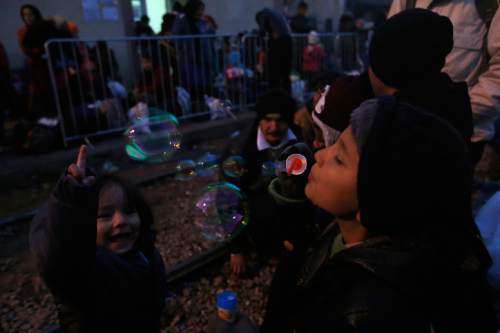 A migrant boy blows soap bubbles as he waits at the railway station in the southern Serbian town of Presevo, Wednesday, Dec. 23, 2015.  As 2015 ends, boat-loads continue to reach the shores of Greek islands from the nearby Turkish coast, while thousands of migrants unlikely to receive refugee status are stranded along the Balkan migrant route, their hopes of reaching the prosperous northern EU countries in jeopardy. (AP Photo/Darko Vojinovic)