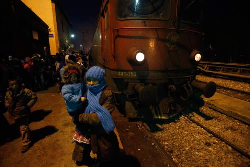 A woman holds her child at the railway station in the southern Serbian town of Presevo, Wednesday, Dec. 23, 2015. As 2015 ends, boat-loads continue to reach the shores of Greek islands from the nearby Turkish coast, while thousands of migrants unlikely to receive refugee status are stranded along the Balkan migrant route, their hopes of reaching the prosperous northern EU countries in jeopardy.  (AP Photo/Darko Vojinovic)