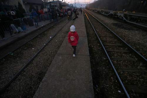 A migrant child walks along  the side of railway tracks at the railway station in the southern Serbian town of Presevo, Wednesday, Dec. 23, 2015. As 2015 ends, boat-loads continue to reach the shores of Greek islands from the nearby Turkish coast, while thousands of migrants unlikely to receive refugee status are stranded along the Balkan migrant route, their hopes of reaching the prosperous northern EU countries in jeopardy.  (AP Photo/Darko Vojinovic)