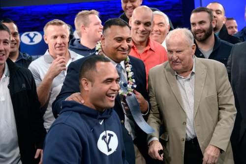 Al Hartmann  |  The Salt Lake Tribune
BYU football players and staff gather around new head coach Kalani Sitake, center, and his old coach Lavell Edwards, right, after a press conference in Provo Monday Dec. 21.