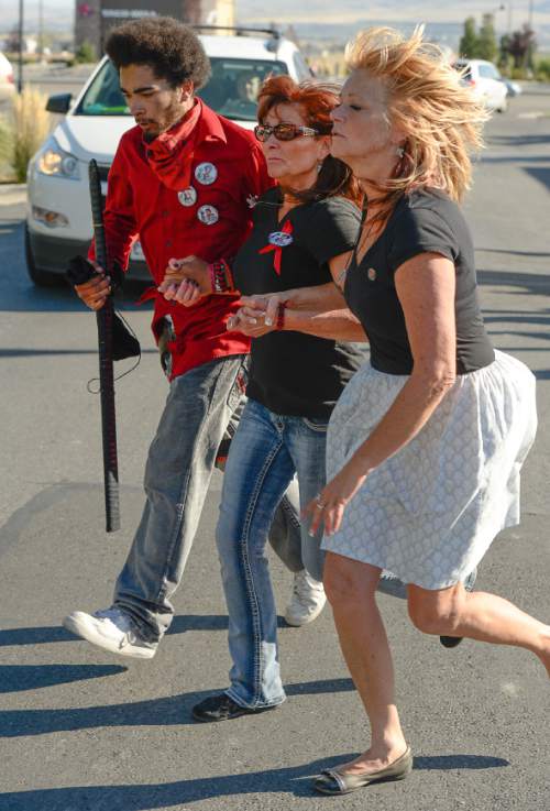 Francisco Kjolseth | The Salt Lake Tribune
Susan Hunt, center, holds her son Kerahn, left, and her sister Cindy Moss, as they make the final run made by Susan's son Darrien Hunt before being shot and killed by police for carrying an ornamental sword in Saratoga Springs one year ago.