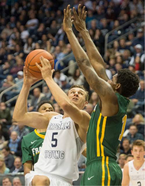 Rick Egan  |  The Salt Lake Tribune

Brigham Young Cougars guard Kyle Collinsworth (5) takes the ball inside as San Francisco Dons forward Dont'e Reynolds (13) defends, in basketball action BYU vs. San Francisco, at the Marriott Center, Saturday, January 9, 2015.