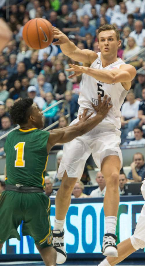 Rick Egan  |  The Salt Lake Tribune

Brigham Young Cougars guard Kyle Collinsworth (5) tosses a pass, as San Francisco Dons guard Devin Watson (1) defends, in basketball action BYU vs. San Francisco, at the Marriott Center, Saturday, January 9, 2015.