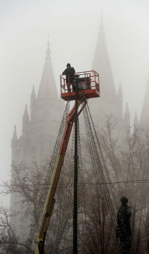 Al Hartmann  |  The Salt Lake Tribune
Maintainence worker on lift removes Christmas lights in the dense fog in front of Temple Square in downtown Salt Lake City Thursday morning  Jan 7.