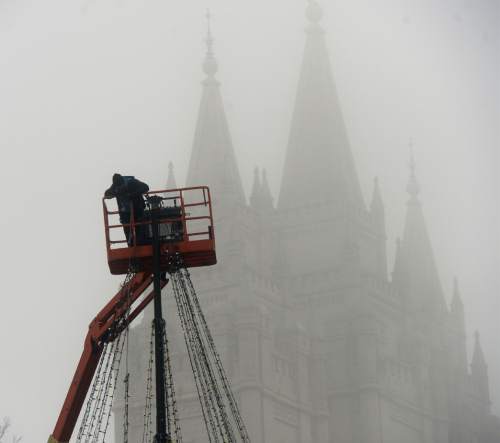 Al Hartmann  |  The Salt Lake Tribune
Maintainence worker on lift removes Christmas lights in the dense fog in front of Temple Square in downtown Salt Lake City Thursday morning  Jan 7.