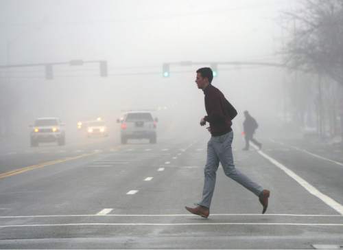 Al Hartmann  |  The Salt Lake Tribune
Commuters and pedestrians move through the dense fog with slippery roads along 200 South in Salt Lake City Thursday morning  Jan 7.
