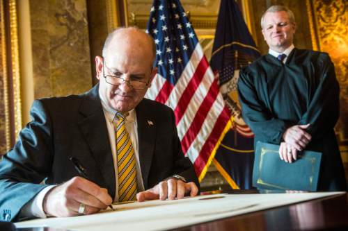 Chris Detrick  |  The Salt Lake Tribune
State Treasurer David Damschen signs the oath of office in the Gold Room of the Utah State Capitol on Wednesday.