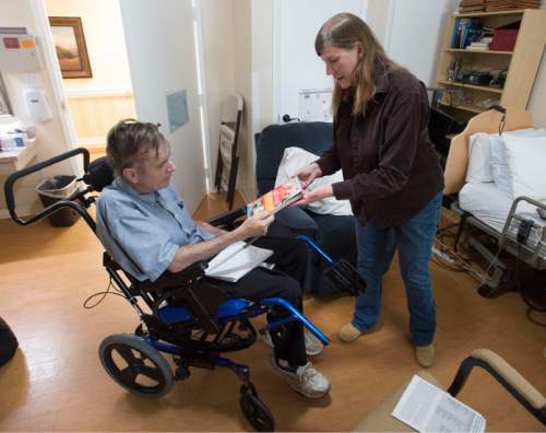 Steve Griffin  |  The Salt Lake Tribune

Utah author and longtime friend Carol Lynch Williams shows Rick Walton, who has written more than 1,000 picture books, a newly published book from one of Rick's former students as she visits him at Orchard Park Rehab in Orem in October 2015. Walton has been diagnosed with a terminal brain tumor and lives in the care facility where author friends -- famous and not -- visit nearly daily, some bringing their latest manuscripts seeking Rick's feedback.