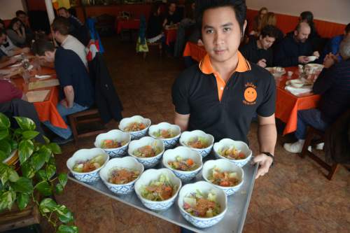 Al Hartmann  |  The Salt Lake Tribune
Waiter Jack Charoenrut serves up salads with peanut sauce to a large lunch group at Krua Thai, a family-owned restaurant in Salt Lake City at 212 E. 500 South in Salt Lake City.