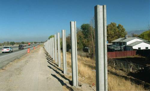 Al Hartmann  |  The Salt Lake Tribune 

Soundwall uprights that will eventually house a slide in panel are going up along I-215 about 4500 South on November 9, 1999.
