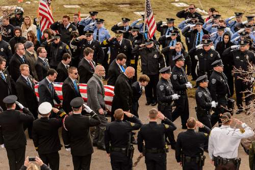 Trent Nelson  |  The Salt Lake Tribune
Officers salute as pallbearers pass, at the graveside service for Officer Douglas Scott Barney, at the Orem Cemetery, Monday January 25, 2016.