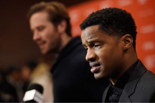 Nate Parker, right, the director, star and producer of "The Birth of a Nation," is interviewed at the premiere of the film at the 2016 Sundance Film Festival on Monday, Jan. 25, 2016, in Park City, Utah. In the background is cast member Armie Hammer. (Photo by Chris Pizzello/Invision/AP)