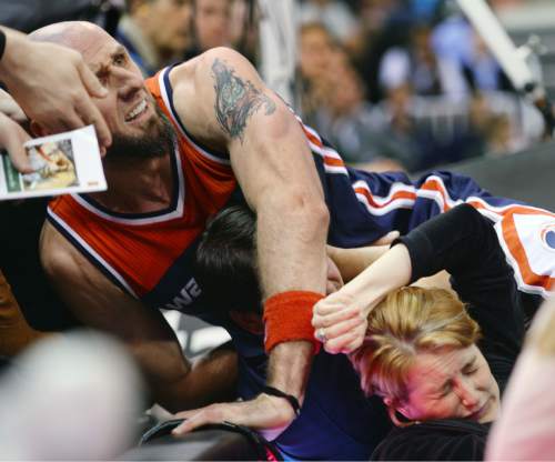 Steve Griffin  |  The Salt Lake Tribune

Washington Wizards center Marcin Gortat (4) crashes into photographers along the baseline as he dives for a loose ball during second half action in the Utah Jazz versus Washington Wizards NBA basketball game at EnergySolutions Arena in Salt Lake City, Wednesday, March 18, 2015.