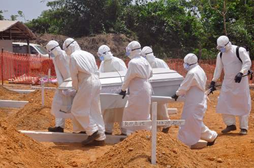 FILE - In this Wednesday, March 11, 2015 file photo, health workers carry a body of a person that they suspected died form the Ebola virus at a new graveyard on the outskirts of Monrovia, Liberia. Activists say international donors have failed to deliver promised funds to help West African countries recover from the Ebola epidemic that killed more than 11,000 people. Oxfam said Sunday, Jan. 31, 2016, that $1.9 billion has not been delivered. (AP Photo/Abbas Dulleh, File)