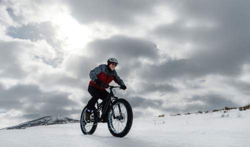 Francisco Kjolseth | The Salt Lake Tribune
Part time Park City resident Bob Brodhead takes his fat bike to the popular trails of Round Valley in Park City as a the sun pokes in and out of a dramatic sky. Locals are excited about the rumor that the city has purchased a two wheel drive motorcycle designed to pull a narrow sled that cuts a single track in the upper trails for the snow biking community.