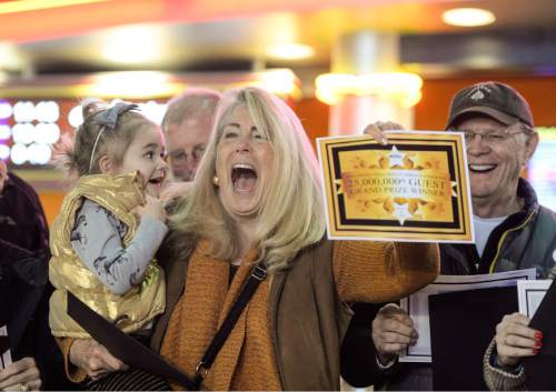 Francisco Kjolseth | The Salt Lake Tribune
Corinne Liddell of Salt Lake City expresses her excitement, surprising her granddaughter Claire Liddell, 3, and her husband Tom, at right, as she wins the golden ticket from Megaplex Theatres in Sandy on Friday morning. Liddell who was among 25 winners, won the grand prize worth $1,000 after being the 25 millionth customer to buy a ticket for the theatre that opened in Nov. of 1999. "We come for the popcorn, they have the best here", exclaimed Corinne, a regular movie goer with her family.