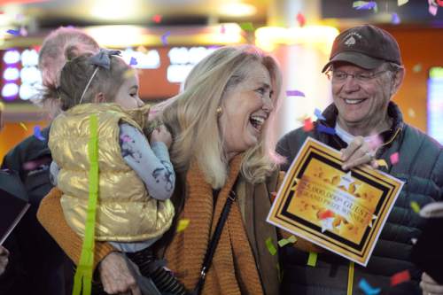 Francisco Kjolseth | The Salt Lake Tribune
Corinne Liddell of Salt Lake City expresses her excitement, as she is joined by her granddaughter Claire Liddell, 3, and her husband Tom, at right, as she wins the golden ticket from Megaplex Theatres in Sandy on Friday morning. Liddell who was among 25 winners, won the grand prize worth $1,000 after being the 25 millionth customer to buy a ticket for the theatre that opened in Nov. of 1999. "We come for the popcorn, they have the best here", exclaimed Corinne, a regular movie goer with her family.
