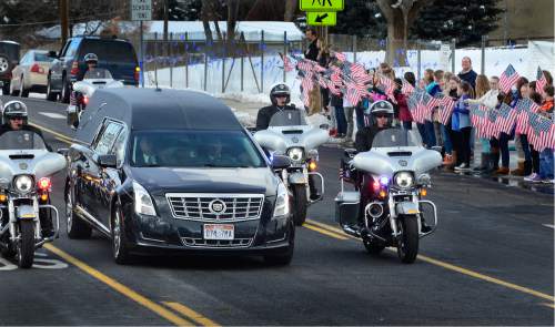 Scott Sommerdorf   |  The Salt Lake Tribune
The hearse carrying Officer Douglas Scott Barney passes Cottonwood Elementary and about 400 of it's students as they lined Holladay Boulevard along the funeral procession, Monday, January 25, 2016.