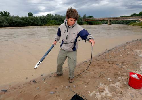 Ben Brown, with the Utah Department of Environmental Quality, takes a pH level reading from a probe in the San Juan River, Tuesday, Aug. 11, 2015, in Montezuma Creek, Utah. A spill containing lead and arsenic from the abandoned Gold King Mine in Silverton, Colo., leaked into the Animas River, which flows into the San Juan River in southern Utah, on Aug. 5. The spill was caused by a mining and safety team working for the EPA.  (AP Photo/Matt York)