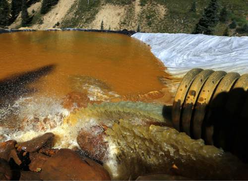 Water flows through a series of sediment retention ponds built to reduce heavy metal and chemical contaminants from the Gold King Mine wastewater accident, in the spillway about 1/4 mile downstream from the mine, outside Silverton, Colo., Friday, Aug. 14, 2015. Officials have said that federal contractors accidentally released more than 3 million gallons of wastewater laden with heavy metals last week at the Gold King Mine near Silverton. The pollution flowed downstream to New Mexico and Utah. (AP Photo/Brennan Linsley)