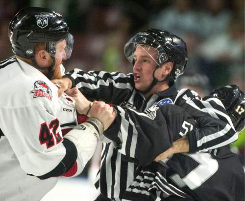 Rick Egan  |  The Salt Lake Tribune

Linesman Official, Andrew Collins, gets caught in the middle, as James Melindy (42), Rapid City Rush fights Utah Grizzlie, T.J. Syner (17) in hockey action Utah Grizzlies vs. The Rapid City Rush, Monday, February 15, 2016.
