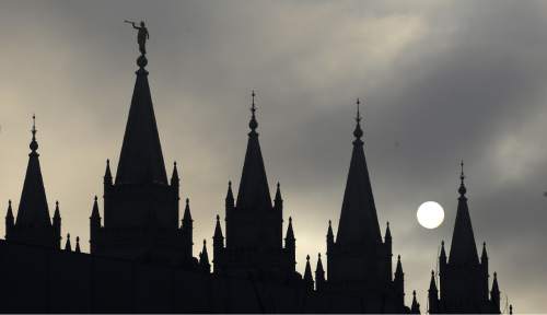 FILE - In this Feb. 6, 2013, file photo, the angel Moroni statue, silhouetted against a cloud-covered sky, sits atop the Salt Lake Temple, at Temple Square, in Salt Lake City. A new Mormon church policy targeting gay members and their children has triggered a firestorm of backlash from church members of all political backgrounds. The new rules bar children living with gay parents from being baptized until they're 18. After that, they can be baptized only if they disavow same-sex relationships. The rules also make gay marriages a sin worthy of expulsion.  (AP Photo/Rick Bowmer, File)