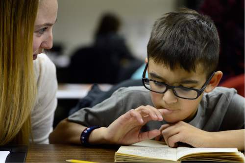Scott Sommerdorf   |  The Salt Lake Tribune
University of Utah student Kailey Stayner listens as  Fourth Grade student Enrique Roman reads. Roman is one of the young students being helped by student tutors at the University of Utah Reading Clinic, Thursday, February 4, 2016.