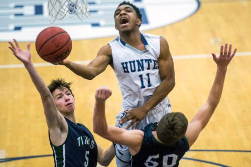 Chris Detrick  |  The Salt Lake Tribune
Hunter's Jaleel Holdford (11) shoots past Syracuse's Alex Christiansen (5) and Syracuse's Michael Hatch (50) during the game at Hunter High School Friday February 19, 2016. Syracuse defeated Hunter 57-51.