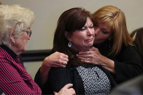 Susan Hunt, center, becomes emotional and is comforted by her sister, Cindy Moss, right, as Hunt waits to be called to appear in court in Saratoga Springs on Friday, Jan. 23, 2014. Susan Hunt, mother of Darrien Hunt, who was shot and killed by Saratoga Springs police while carrying a sword in September, is facing misdemeanor charges stemming from a reported confrontation she had with officers from that police department in October. SPENSER HEAPS, Daily Herald