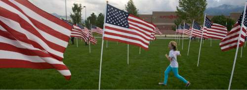 Rick Egan  | The Salt Lake Tribune 

Leah Hurt, 8, runs through the flags in the healing field, before the 911ceremony in front of the Sandy City Hall, Wednesday, September 11, 2013.
