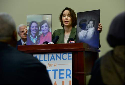 Scott Sommerdorf   |  The Salt Lake Tribune
Karina Brown, citizen in the coverage gap, shows photos of her mother as she speaks at a press conference of community leaders, advocates and medical professionals encouraging lawmakers to act on healthcare, Wednesday, February 24, 2016. Brown made the point that she feels her mother would still be alive if she had better access to healthcare.