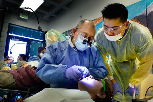 Scott Sommerdorf   |  The Salt Lake Tribune  
Doctor Ken King, left, checks the work done for patient Liliana Uriza done by dental student Harris Yu, right, at the semi-annual free dental fair at Horizonte organized by the Junior League of Salt Lake City on Saturday.