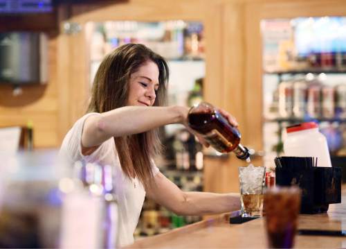 FILE - In this Feb. 6, 2016, file photo, Jen Shaul, a bartender at Buck's Saloon in Melba, Idaho, pours whiskey at the bar. On Wednesday, March 2, 2016, payroll processor ADP reports how many jobs private employers added in February. (Adam Eschbach/Idaho Press-Tribune via AP, File) MANDATORY CREDIT