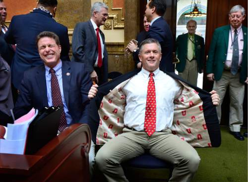 Scott Sommerdorf   |  The Salt Lake Tribune  
Utah head football coach Kyle Whittingham shows off his "U" jacket lining as Rep. Jim Dunnigan, R-Taylorsville, left laughs in response. BYU head coach Kelani Sitake and Whittingham visited the House and caused quite a stir on the floor as Rep. Carol Spackman-Moss was trying to present her bill, HB221 - Immunization of Students Amendments - in the Utah House of Representatives, Thursday, March 3, 2016.