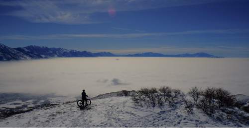 Francisco Kjolseth | The Salt Lake Tribune
Jason Dunn of Draper seeks higher, cleaner air as he rides his bike to a peak overlooking the obscured Utah county as air quality continues to deteriorate with inversion conditions trapping cold air on Friday, Feb. 12, 2016.