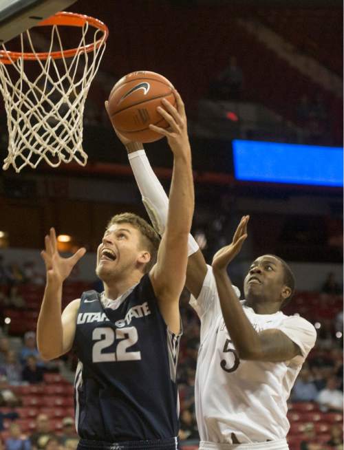 Rick Egan  |  The Salt Lake Tribune

Utah State Aggies forward Quinn Taylor (22) scores as Wyoming Cowboys forward Alan Herndon (5) defends for the Wyoming Cowboys in Mountain West Conference playoff action, at the Thomas & Mack Center, in Las Vegas, Wednesday, March 8, 2016.
