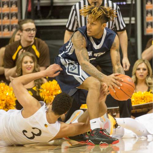 Rick Egan  |  The Salt Lake Tribune

Utah State Aggies guard Shane Rector (4) grabs a loose ball from Wyoming Cowboys guard Alexander Aka Gorski (3), in the Mountain West Conference playoff action, at the Thomas & Mack Center, in Las Vegas, Wednesday, March 8, 2016.