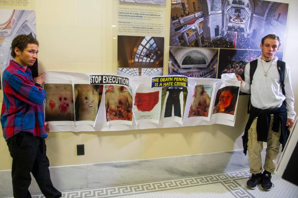 Chris Detrick  |  The Salt Lake Tribune
Two unidentified men hold up autopsy photos of Ronnie Lee Gardner at the Utah Capitol on Thursday, March 10, 2016. Randy Gardner, Ronnie Lee Gardner's brother, disrupted the House to protest the death penalty.