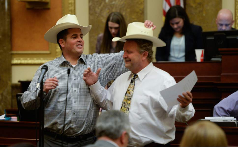 Francisco Kjolseth | The Salt Lake Tribune
Rep. Mike McKell, R-Spanish Fork, left, tries to swap out a hat that might fit him with Rep. Rich Cunningham, R-South Jordan, as they get ready to sing a funny song to the tune of Sweet Home Alabama following the conclusion of the Legislative session at midnight on Thursday, March 10, 2016.